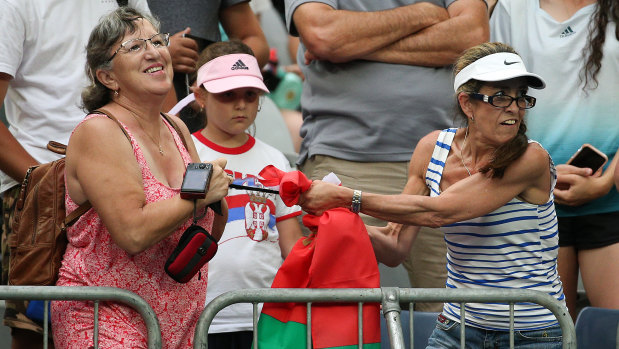 Two fans fight over Aryna Sabalenka's sweaty black headband. 