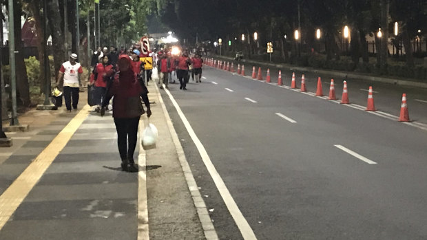 Locals, fearing a bomb attack, leave the Gelora Bung Karno Stadium complex in Jakarta on Sunday night.