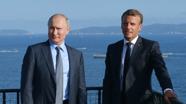 French President Emmanuel Macron, right, and Russian President Vladimir Putin pose for a photo during their meeting at the fort of Bregancon in Bormes-les-Mimosas, southern France, ahead of the G7 which Putin does not attend.