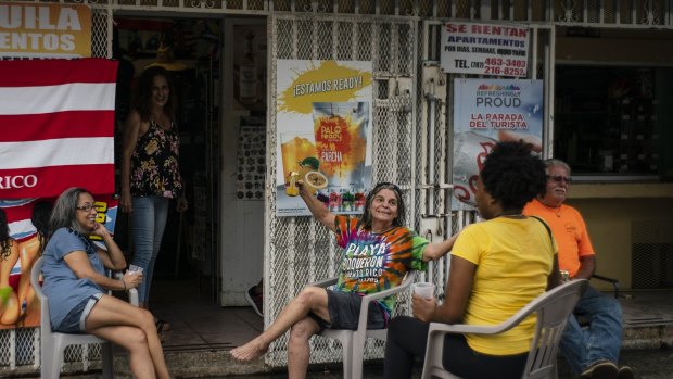 People drink beer on a patio before the arrival of Dorian in Boqueron, Puerto Rico.