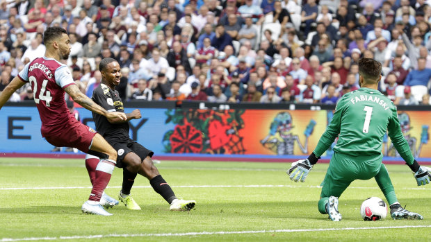 Bright start: Raheem Sterling guides the ball past West Ham goalkeeper Lukasz Fabianski for City's second goal at London Stadium.