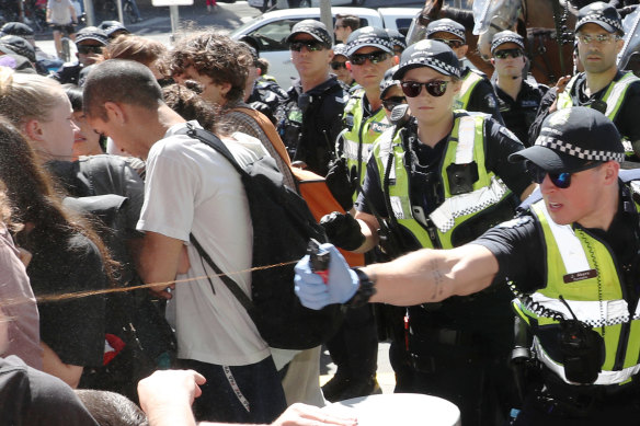 Police use pepper spray on protesters as they tried to stop conference members entering IMARC.
