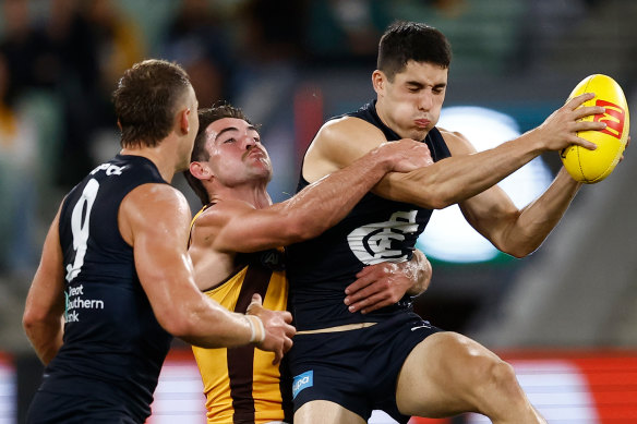 Adam Cerra is tackled by Jai Newcombe.