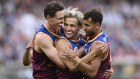 Brisbane’s Eric Hipwood, Kai Lohmann and Callum Ah Chee embrace during the AFL grand final.