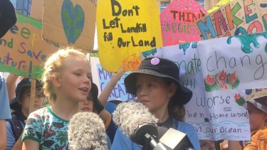 Thea, 8, and Elia Reid, 11, front the media pack at the Brisbane rally for climate change.