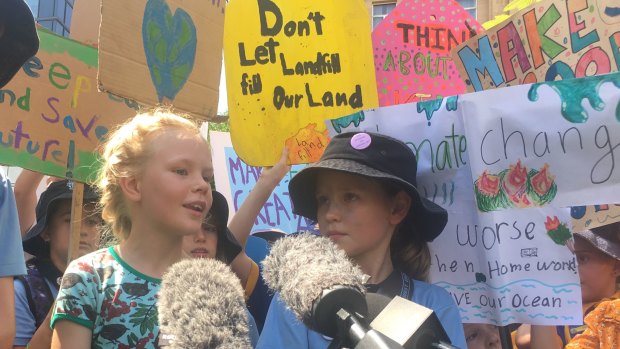 Thea, 8, and Elia Reid, 11, front the media pack at the Brisbane rally for climate change.