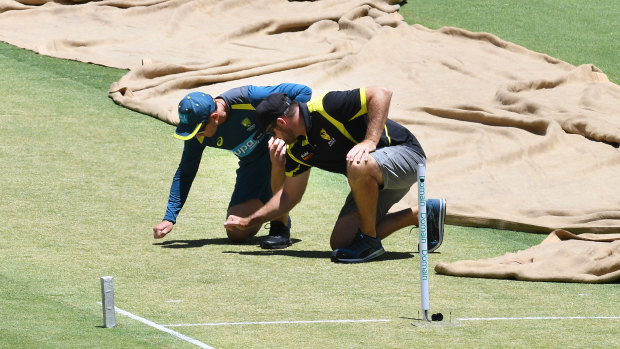 Australian coach Justin Langer and Optus Stadium curator Brett Sipthorpe inspect the pitch.