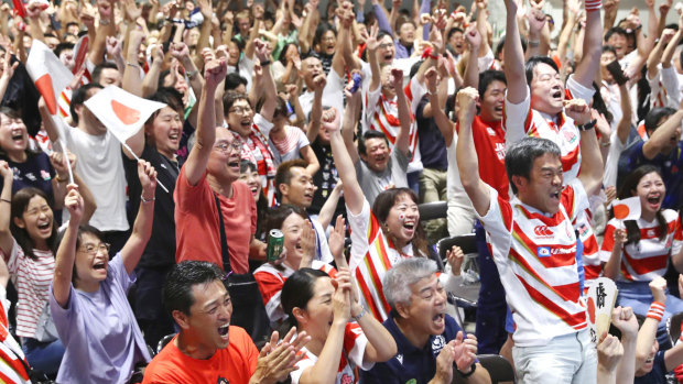 Supporters at a public-viewing event celebrate as Japan score a try against Ireland.