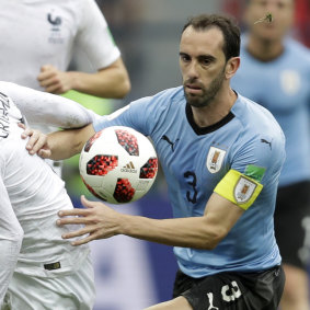 Uruguay's Diego Godin in action with France's Antoine Griezmann.