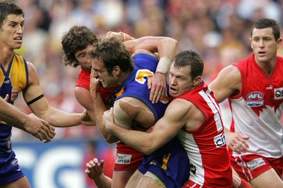 Chris Judd is tackled by Paul Williams and Brett Kirk in the 2005 decider.