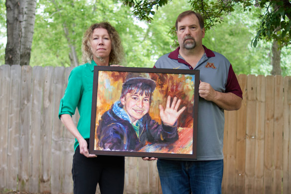 Minnesota parents Melissa and Jim Crowley hold a portrait of their son Alex Crowley, who attended a school close to a 3M facility and died of brain cancer.