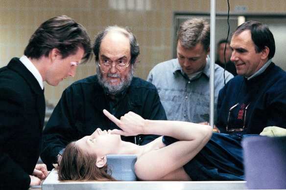 Stanley Kubrick and Tom Cruise (left), with Julienne Davis as the corpse and director of photography Larry Smith (right) on the set of Eyes Wide Shut.