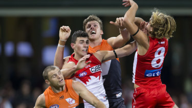 Aerial dispute: Tom McCartin and James Rowbottom of the Swans and Sam J.Reid of the Giants compete for a mark.