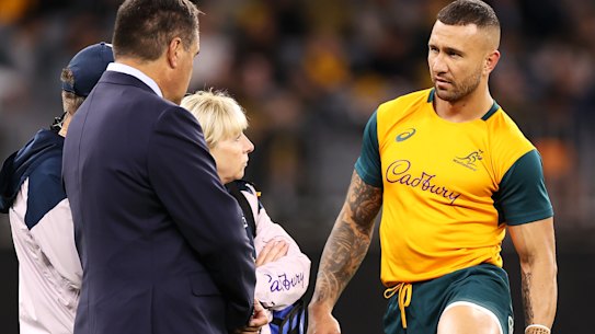 Quade Cooper speaks to coaching and medical staff during the warm-up before the first Test against England. 