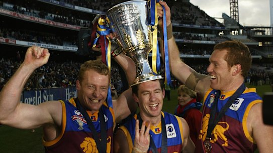 Craig McRae (centre) with Michael Voss and Justin Leppitsch after the Brisbane Lions’ third premiership in 2004.