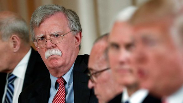 Then national security adviser John Bolton listens to US President Donald Trump in 2018. His earlier claims directly challenged Trump's position on Ukraine.