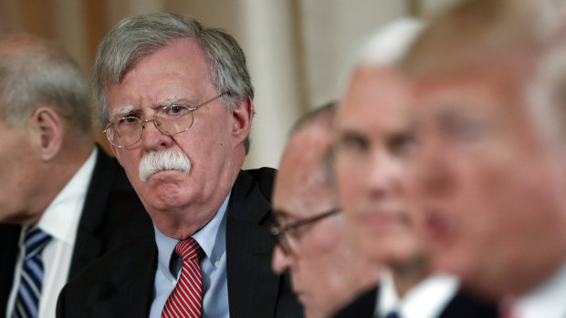 Then national security adviser John Bolton listens to US President Donald Trump in 2018. His earlier claims directly challenged Trump's position on Ukraine.