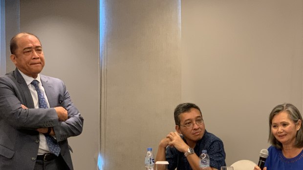 Exiled Cambodian opposition leader Mu Sochua, right, speaks at a press conference in Jakarta, next to  Indonesian activist Darmawan. Cambodian ambassador to Indonesia Hor Nam Bora - who tried to stop the event - looms over the pair.