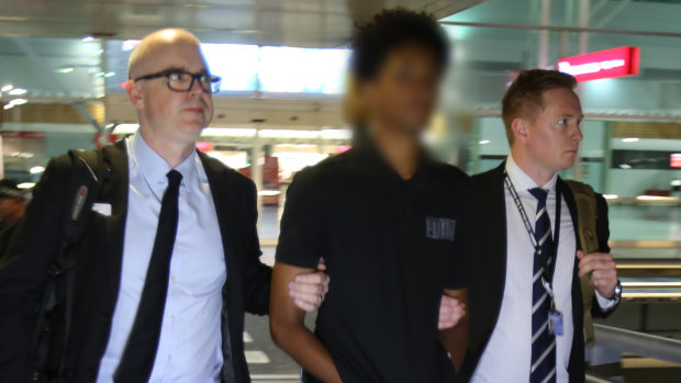 AFP officers arrested the man (centre) after he arrived at Adelaide Airport on an international flight.