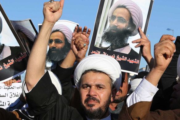Iraqi Shiites protest against the Saudi government as they hold posters showing Sheikh Nimr al-Nimr, who was executed in Saudi Arabia.