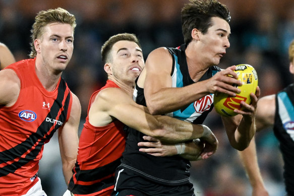 Connor Rozee of the Power tackled by Zach Merrett of the Bombers.