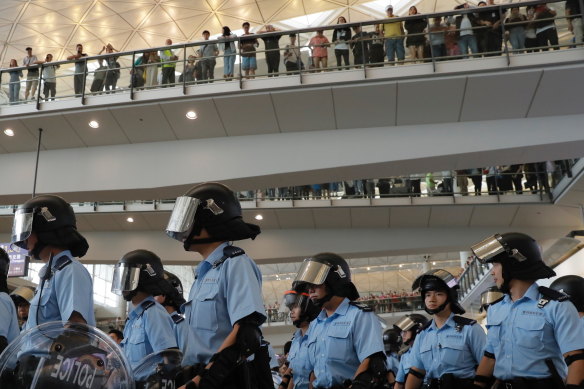 Police take positions as pro-democracy protesters gather outside the airport in Hong Kong on Sunday.