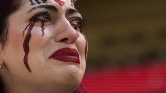An Iranian woman cries after a security guard seized her flag reading “Woman Life Freedom” before the start of the Wales v Iran match at the Ahmad Bin Ali Stadium in Al Rayyan, Qatar, on Friday.