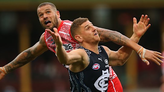 Lance Franklin battles Jacob Weitering of the Blues for possession. 