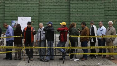 People wait in line for the voting booths to open during the presidential election in Bogota, Colombia, on Sunday.