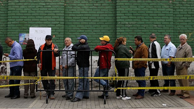 People wait in line for the voting booths to open during the presidential election in Bogota, Colombia, on Sunday.