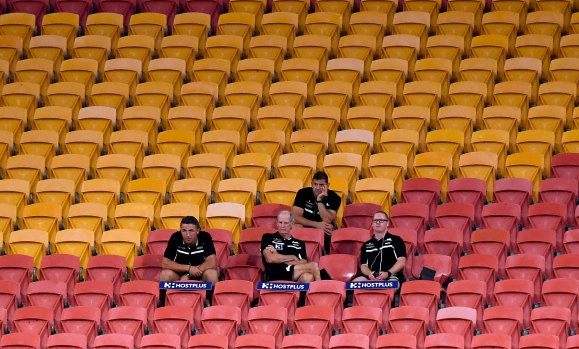 Rabbitohs coach Wayne Bennett and his coaching staff in the empty stands for their match against the Broncos in round two.