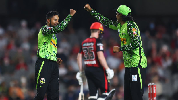 Tanveer Sangha and Jason Sangha celebrate a wicket. 