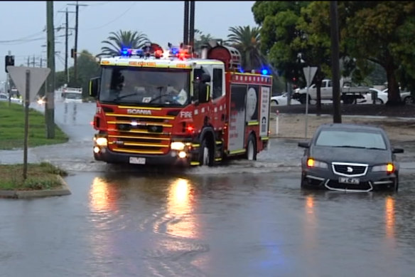 Vehicles get stuck in flooded streets in Corio this afternoon.