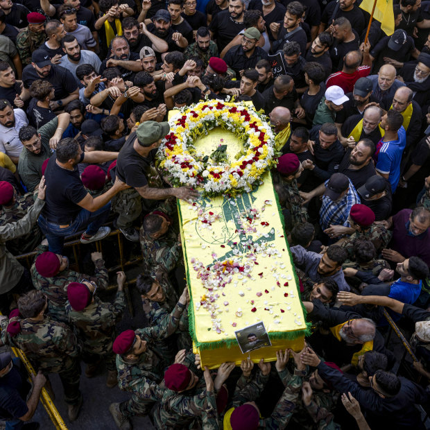 Mourners walk with a coffin during a funeral for four people killed in the pager attack.