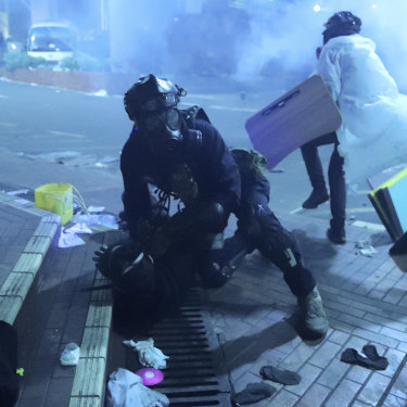 A policeman detains a protester outside of Hong Kong Polytechnic University as police storm the campus  on November 18.