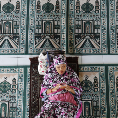 A woman rests at a mosque on the first day of Ramadan in Bali.