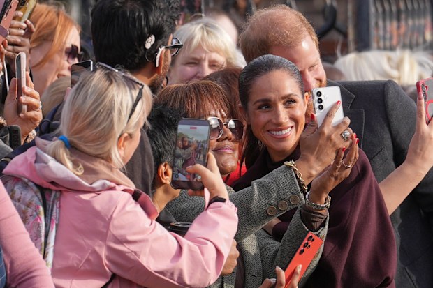 Britain’s Prince Harry and Meghan, Duke and Duchess of Sussex pose for photographs with members of the public as they arrive for a visit to The Community Recording Studio in Nottingham