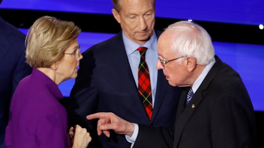Democratic presidential candidate Sen. Elizabeth Warren, D-Mass., left and Sen. Bernie Sanders, I-Vt., talk Tuesday, Jan. 14, 2020, after a Democratic presidential primary debate hosted by CNN and the Des Moines Register in Des Moines, Iowa. Candidate businessman Tom Steyer looks on.