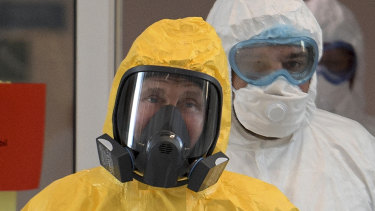 Russian President Vladimir Putin wears a yellow hazmat suit to visit a hospital for coronavirus infected patients last month.