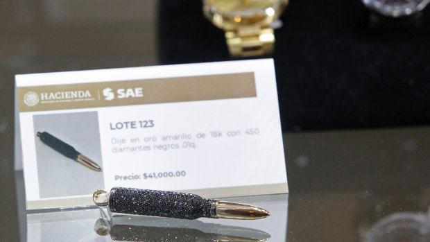 A necklace pendant made of yellow gold with 450 black diamonds in the shape of a bullet is displayed during the auction of items seized from purported drug dealers and tax cheats. 