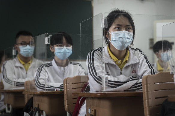 Senior students study in a Wuhan classroom with shields on each desk as a protection against coronavirus. About 57,800 students in their final year went back to school on Wednesday in Wuhan.