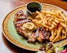 Steak with anchovy-and-confit-garlic butter and bottomless fries at Allegro.