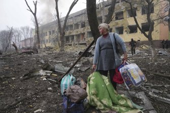 A woman walks outside the maternity hospital that was damaged by shelling in Mariupol.