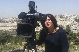 In this undated photo provided by al-Jazeera, Shireen Abu Akleh stands next to a TV camera in Jerusalem.