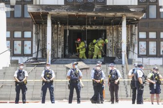 Firefighters responding at the fire-damaged front entrance of Old Parliament House following a protest, in Canberra on December 30.