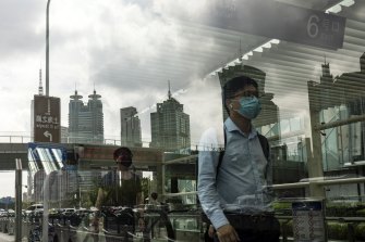 Şanghay'ın iş bölgesindeki yayalar.  Geçen hafta vakalarda bir artış, şehrin tekrar tecrit altına alınacağı endişesini körükledi. 