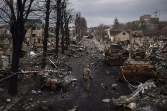 Dismissed as a hoax, A Ukrainian serviceman walks amid destroyed Russian tanks in Bucha, Ukraine, the scene of suspected Russian war crimes.