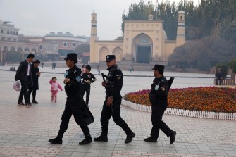 Security personnel on patrol outside a mosque attended by Uighurs in Xinjiang.