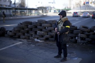 A man guards a checkpoint in Kyiv on Saturday.