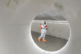 A worker wearing a protective suit sprays disinfectant at the Centrum subway station in Warsaw. 